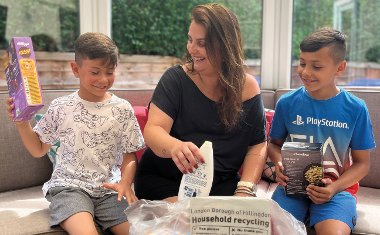 A woman and two young children sort recycling into a Hillingdon recycling bag