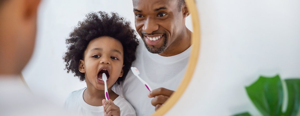 Photo of father and child brushing teeth in the bathroom
