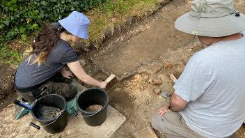 People excavate a ditch as part of an archaeological dig