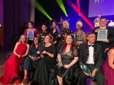 Kelly Johns - seated front row with long red hair - holding her Children & Young People award at the ceremony