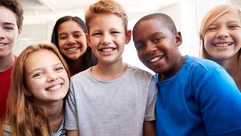 six children smile at the camera