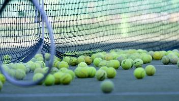 Tennis racket and balls on court
