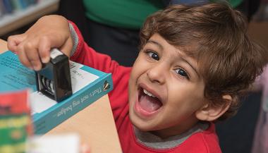 Little boy holding a book date stamp
