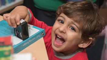 Little boy holding a book date stamp