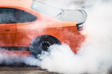 A sports car does a wheelspin creating tyre smoke
