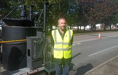 Cllr Jonathan Bianco next to a RoadMender machine like the one the council will use