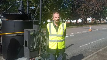 Cllr Jonathan Bianco next to a RoadMender machine like the one the council will use