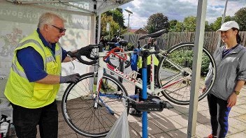 Man in high vis fixes woman's bike