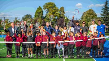 Cllrs, staff and children from Harmondsworth Primary stand at the net of a renovated tennis court in Harmondsworth Rec
