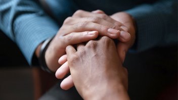 A couple sitting close hold hands