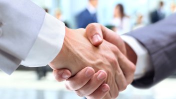 Two people shaking hands in smart work attire