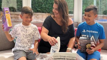 A woman and two young children sort recycling into a Hillingdon recycling bag