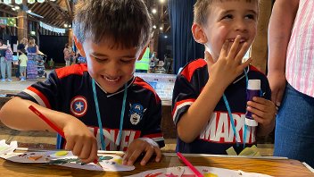 Two young boys smiling and laughing while crafting