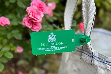 Green Hillingdon garden waste tag attached to a garden waste sack