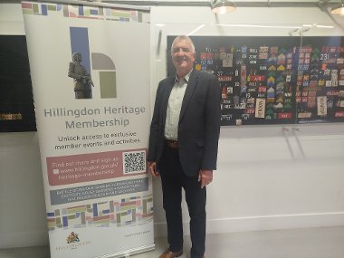 Cllr Eddie Lavery next to the Heritage Membership pull-up banner at the Battle of Britain Bunker