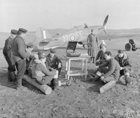 RAF personnel and Soviet sailors gather round a gramophone