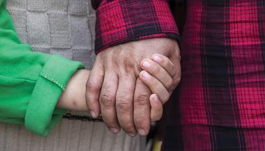 Adult and child holding hands