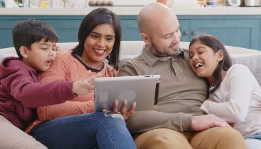 Family on sofa using a tablet